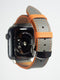 Apple watch bands in gray Swift leather with orange stitching, combining style with a pop of color.