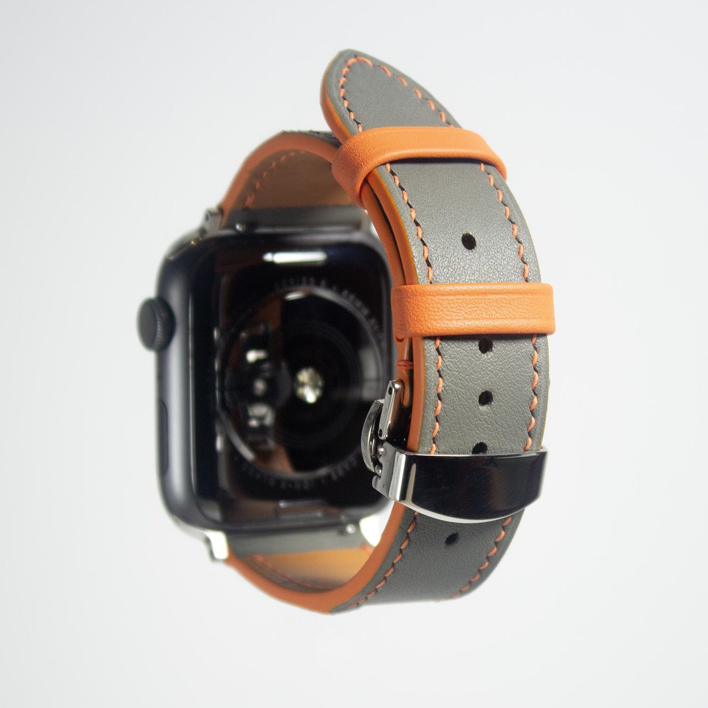 Apple watch bands in gray Swift leather with orange stitching, combining style with a pop of color.